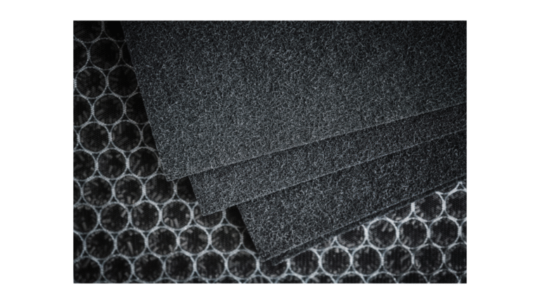 Close-up view of activated carbon filter sheets used in a carbon filtration system for air purification and odor control.