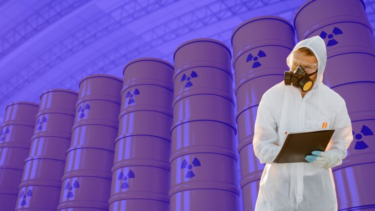 Safety inspector in protective suit examining radioactive waste barrels at industrial storage facility